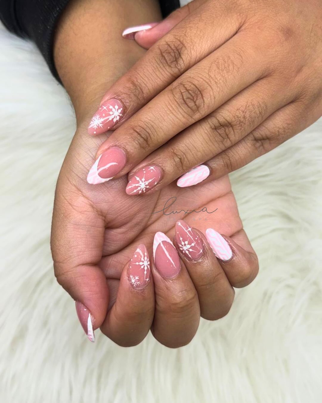 Pink almond nails with white snowflake and candy cane art