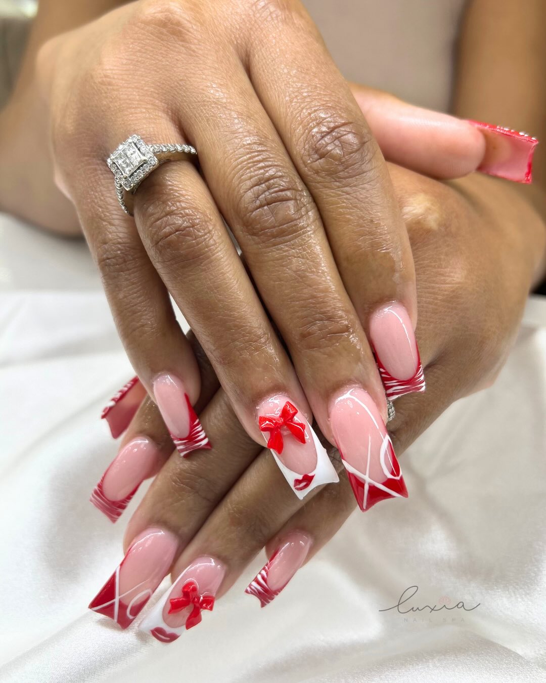 Valentine red French tips with 3D bow accents