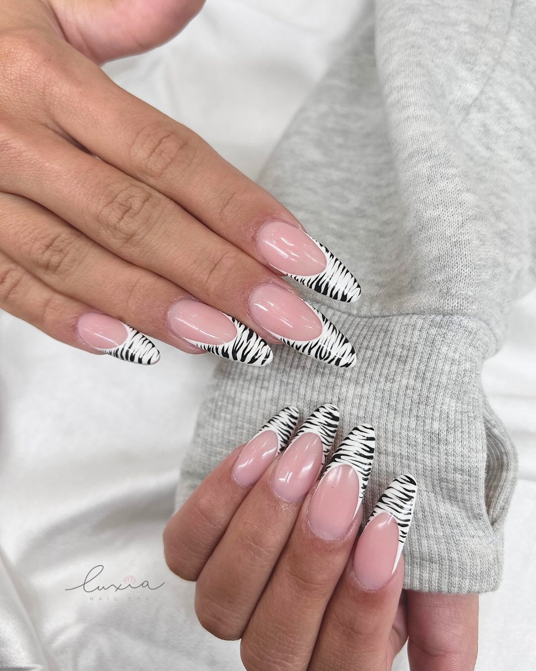 Nude almond nails with zebra print French tips